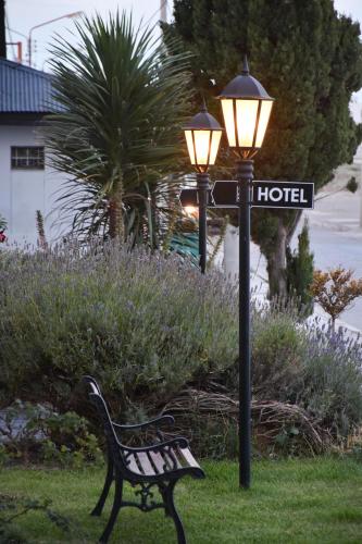 a park bench next to a street light with a street sign at Hotel Playa in Comodoro Rivadavia