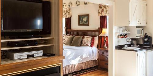 a bedroom with a bed and a flat screen tv at Rose Hill Retreat AAA Four Diamond Inn in Stonewall