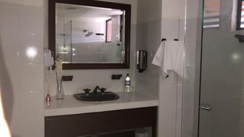 a bathroom with a sink and a mirror and a shower at Chalet la Bonita in El Encano