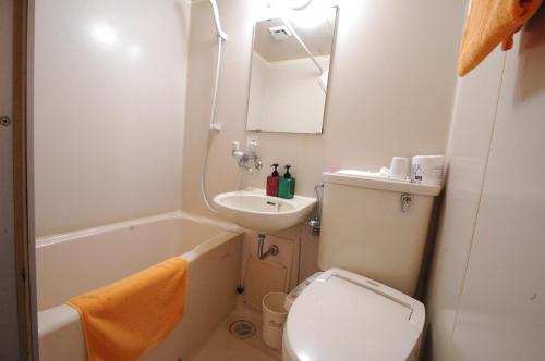 Hotel kakuban في يوناغو: حمام صغير مع مرحاض ومغسلة