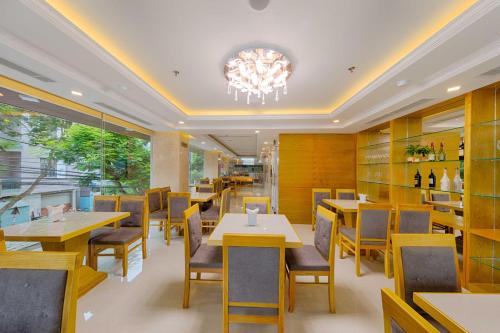 un restaurante con mesas y sillas y una lámpara de araña en Rosabella Boutique Hotel en Da Nang