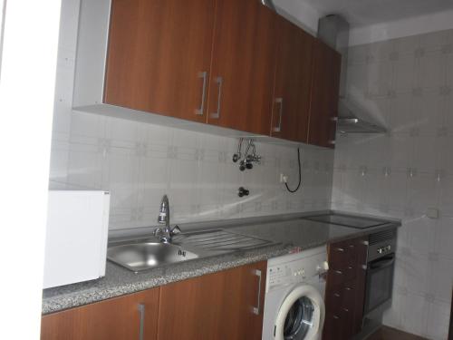 a kitchen with a sink and a washing machine at Blue Apartment in Portimão