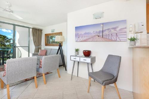 a living room with a table and two chairs and a desk at Malibu Apartments in Mooloolaba