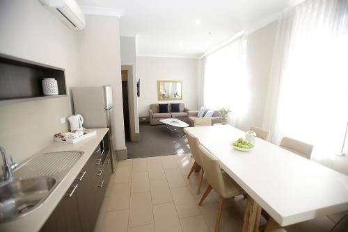 a kitchen with a sink, a refrigerator and a dishwasher at Hotel Bondi in Sydney