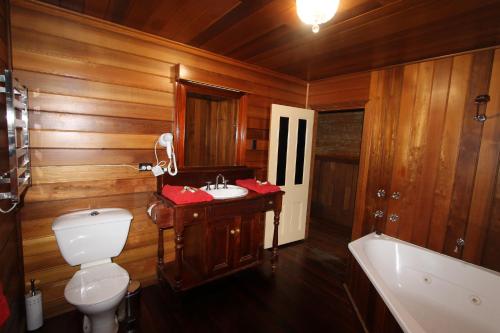 a wooden bathroom with a toilet and a sink at Kerrellie Cottages 2, 4 & 8 Reid Street in Strahan