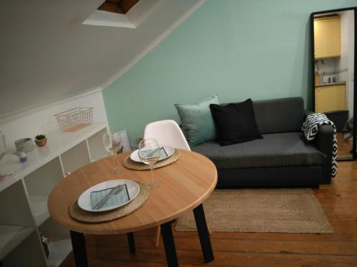 uma sala de estar com uma mesa e um sofá em Cactus House Lisboa em Lisboa