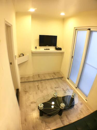 a room with a table on the floor with a tv at Dong-Qing Swiss Homestay in Chaozhou