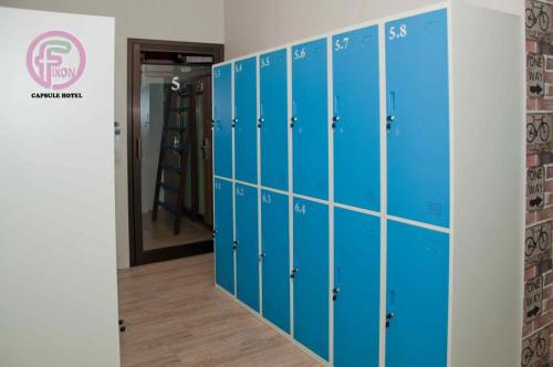 a row of blue lockers in a room at FixOn Capsule Hotel in Purwokerto