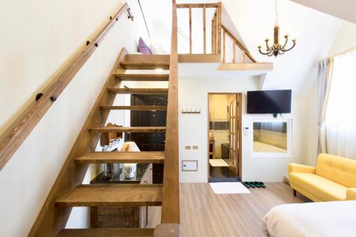 a staircase in a room with a yellow couch at Puli Story House in Puli
