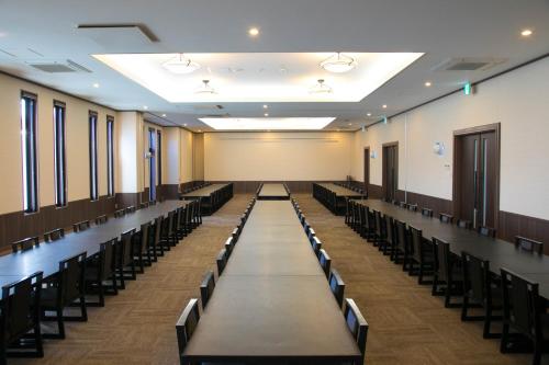 an empty room with rows of tables and chairs at Ofunato Onsen in Ōfunato