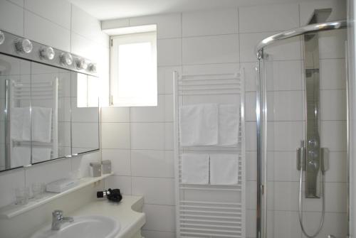 a white bathroom with a shower and a sink at Ferienwohnung St. Martin 28 in Techelsberg am Worthersee