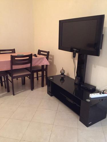 a living room with a flat screen tv and a table at ESC Apartments in Fès