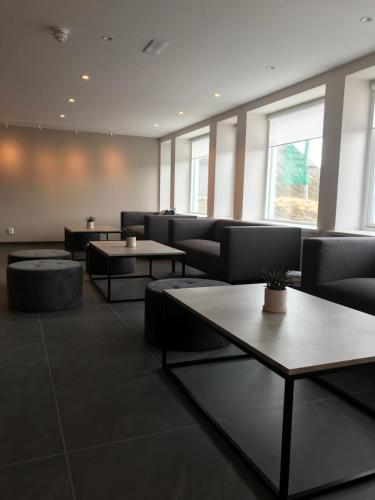 a waiting room with couches and tables and windows at The View in Honningsvåg