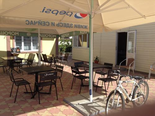 a group of tables and chairs under an umbrella at Hotel Olympia in Adler