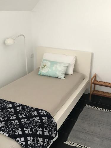 een bed met een kussen en een stoel in een kamer bij Ferienwohnung Landart in Hilter