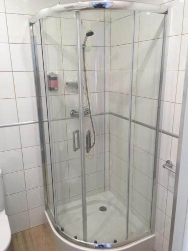 y baño con ducha y puerta de cristal. en Hotel&Restauracja Złote Runo, en Góra Kalwaria