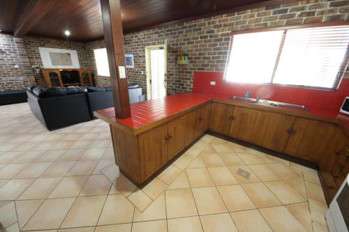 a kitchen with a red counter in a room at Sandy Feet at Hat Head - No Sheets or Towels Provided in Hat Head