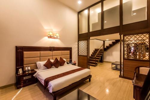 a bedroom with a large bed and a staircase at Golden Chariot Vasai Hotel in Vasai
