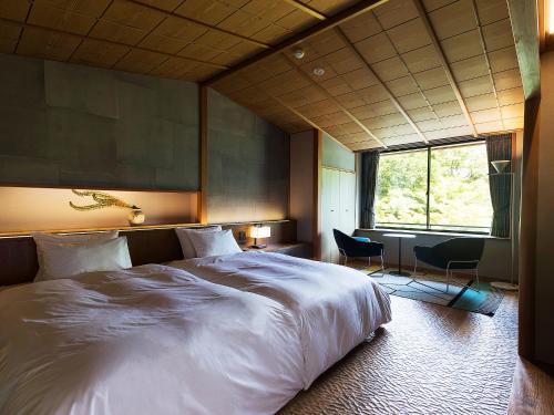 a bedroom with a large white bed and a window at Nanzenji sando KIKUSUI in Kyoto