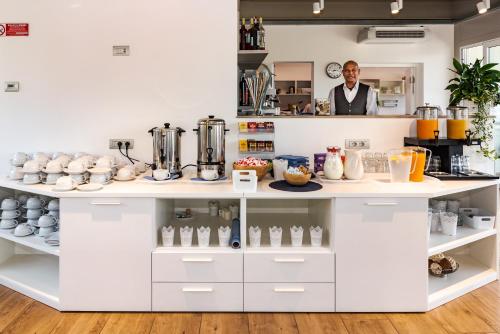 a man standing behind a counter in a kitchen at Hotel Vischi in Domaso