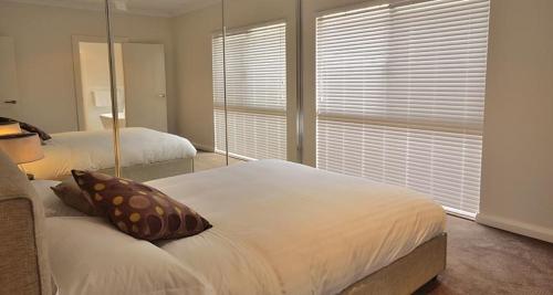 a bedroom with two beds and a large window at The Carnarvon Luxury Canal Home in Carnarvon
