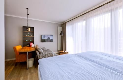 a bedroom with a bed and a table and a chair at Logierhaus RheintorEins in Rees