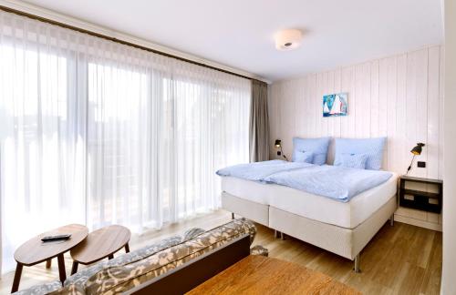 a bedroom with a bed and a couch in front of a window at Logierhaus RheintorEins in Rees