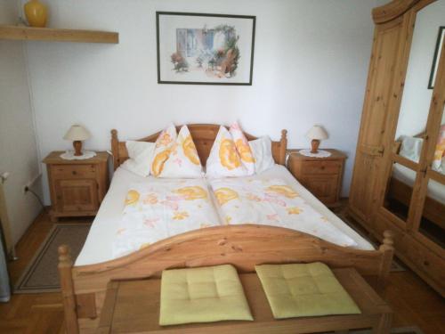 バート・ラトカースブルクにあるGästehaus Schleichのベッドルーム1室(木製ベッド1台、ナイトスタンド2台付)