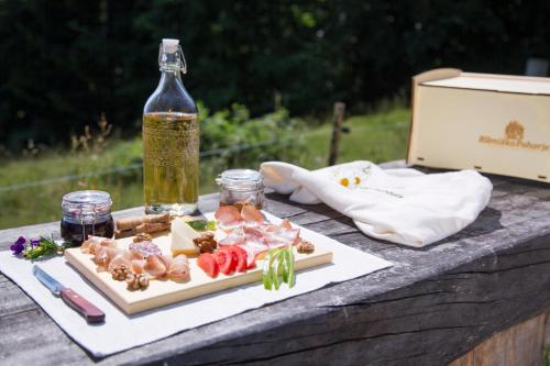 a table with a plate of food and a bottle of oil at Lake Peak Apartments, Ribniško Pohorje in Ribnica na Pohorju