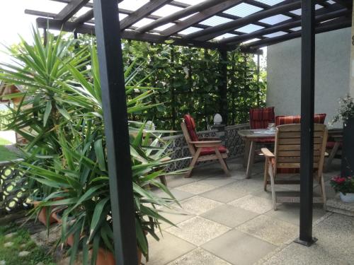 a patio with a pergola and chairs and plants at Gästehaus Schleich in Bad Radkersburg
