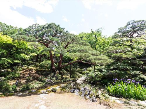 a garden with a tree and some flowers and trees at Nanzenji sando KIKUSUI in Kyoto