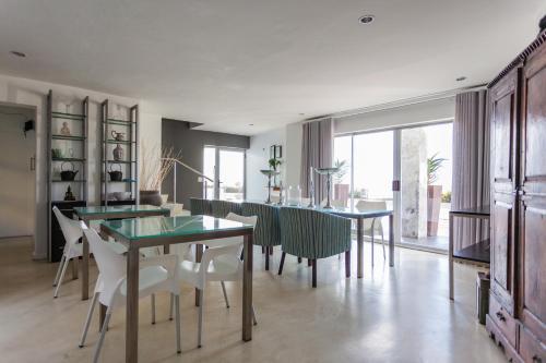 a dining room with tables and chairs and a large window at Agulhas Ocean House in Agulhas
