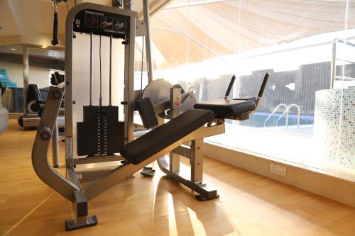 a gym with a cardio machine in a room with a pool at Somewhere Hotel Al Ahsa in Al Hofuf