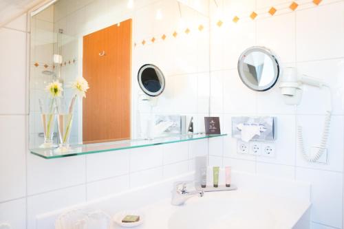 a bathroom with a sink and a mirror at Hotel Seeperle in Langenargen