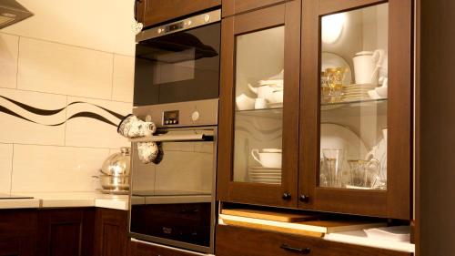 捷克卡梅尼采的住宿－U Salonu VIRGINIA，厨房配有玻璃橱柜,内有餐具
