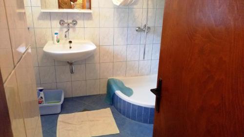 ein Badezimmer mit einem Waschbecken, einer Badewanne, einem Waschbecken und einem Waschbecken in der Unterkunft Holiday House Klevini Dvori in Olib