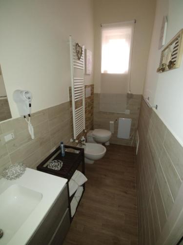 a bathroom with two toilets and a sink at Diadumeno Superior Apartment in Venosa