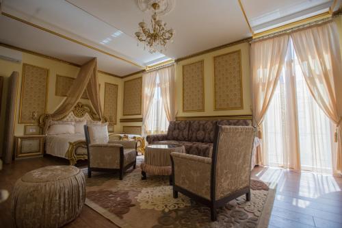 a bedroom with a bed and a couch and chairs at Robevski luxury rooms in Bitola