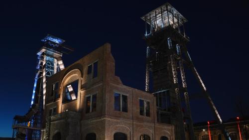 a building with a crane in the background at night at B&B Eikenlaan 12 in Genk