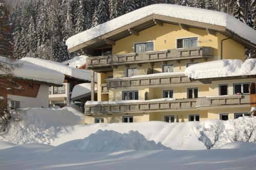 ein schneebedecktes Gebäude mit einem Stapel Schnee in der Unterkunft Haus Lechner Apartments in Sankt Jakob in Haus