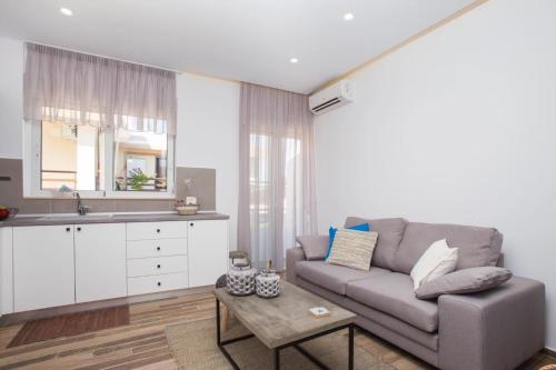 a living room with a couch and a table at Elenis Philoxenia in Ixia