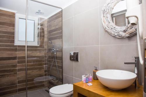 a bathroom with a sink and a toilet and a shower at Elenis Philoxenia in Ixia