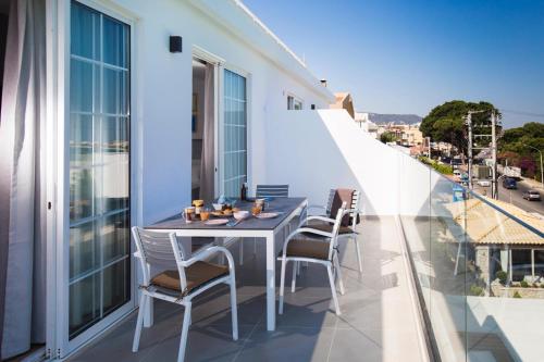 a balcony with a table and chairs on a building at Elenis Philoxenia in Ixia
