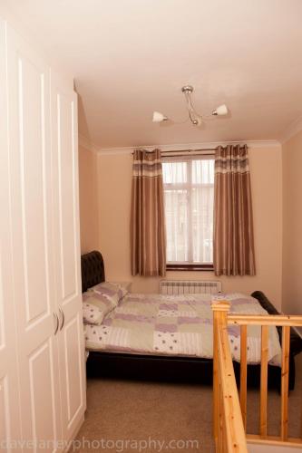a bedroom with a bed and a window at Home from Home in Ilford