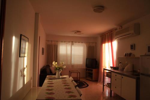 a kitchen with a table with a vase of flowers on it at Kinneret Guesthouse in Neot Golan