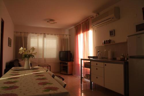 una cocina con una mesa con un jarrón de flores. en Kinneret Guesthouse, en Neot Golan