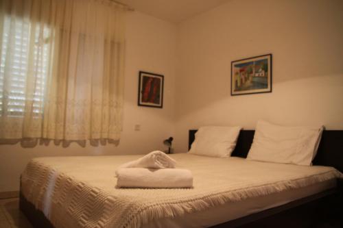 a bed with a white towel on top of it at Kinneret Guesthouse in Neot Golan