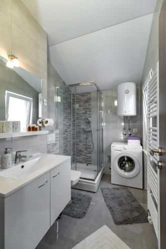a bathroom with a sink and a washing machine at Arenta Apartments in Metković