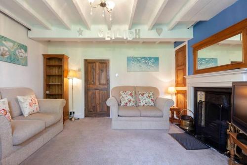 a living room with two couches and a fireplace at Ceilidh Cottage in York