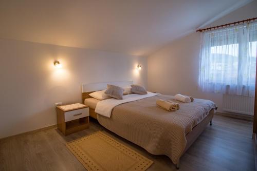 a bedroom with a bed with two pillows on it at Arenta Apartments in Metković